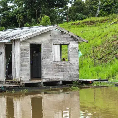 Casa flutuante de madeira, com um cachorro descansando no deque