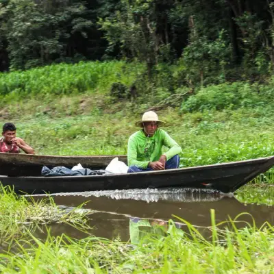 Pescadores ribeirinhos em canoa junto à margem