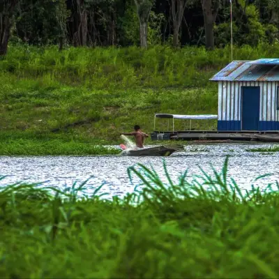 Casa flutuante azul ancorada junto à mata