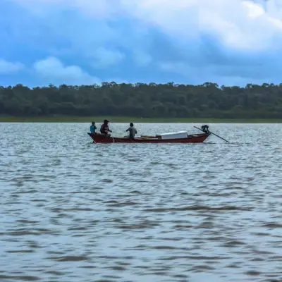 Canoa cruzando o lago sob céu azul de nuvens altas